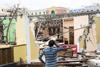 An image showing a puzzled man looking at the damaged that the Hurricane Maria in Puerto Rico had done to a house